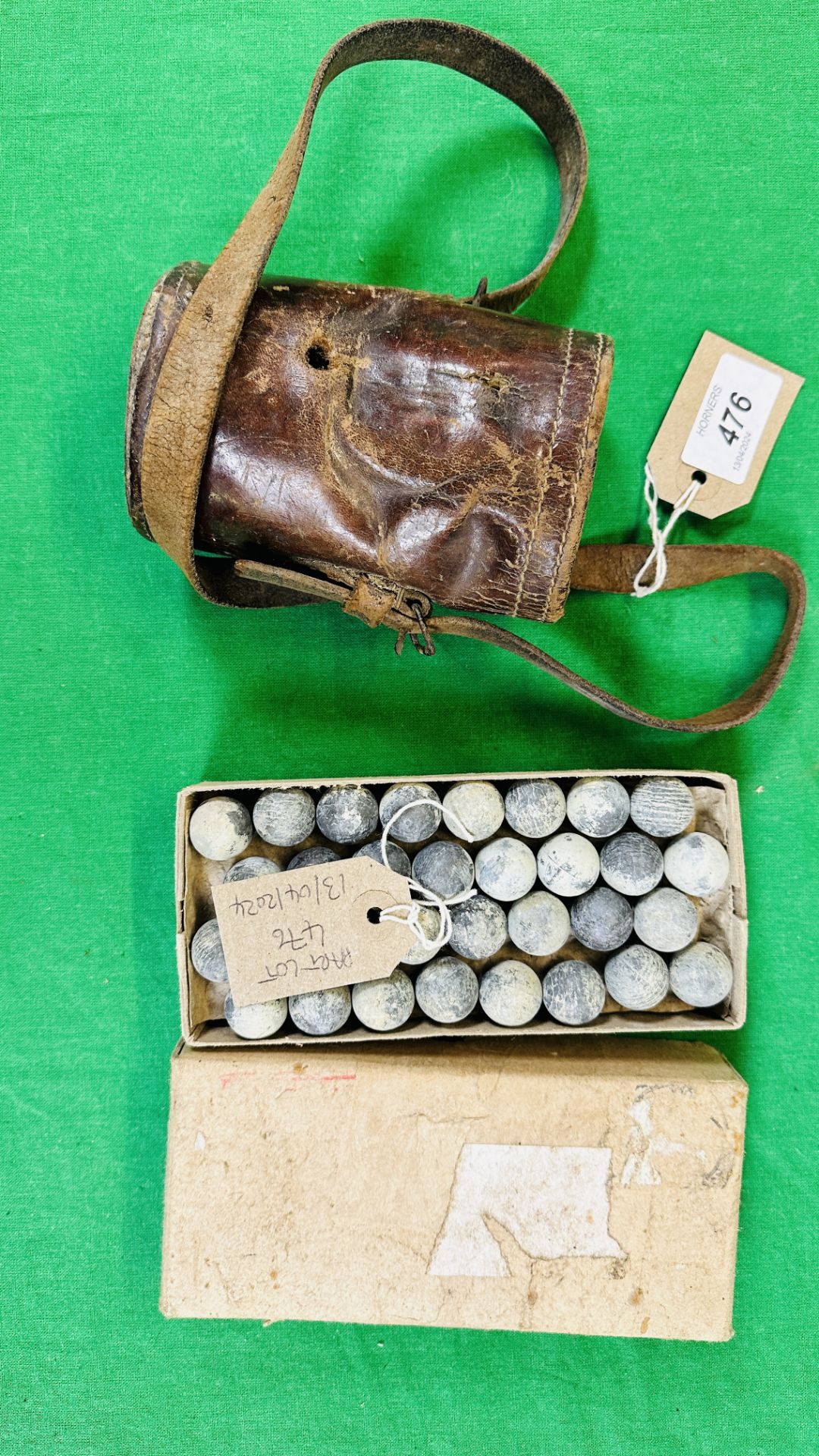 A BOX CONTAINING LEAD MUSKET BALLS AND VINTAGE LEATHER POUCH.