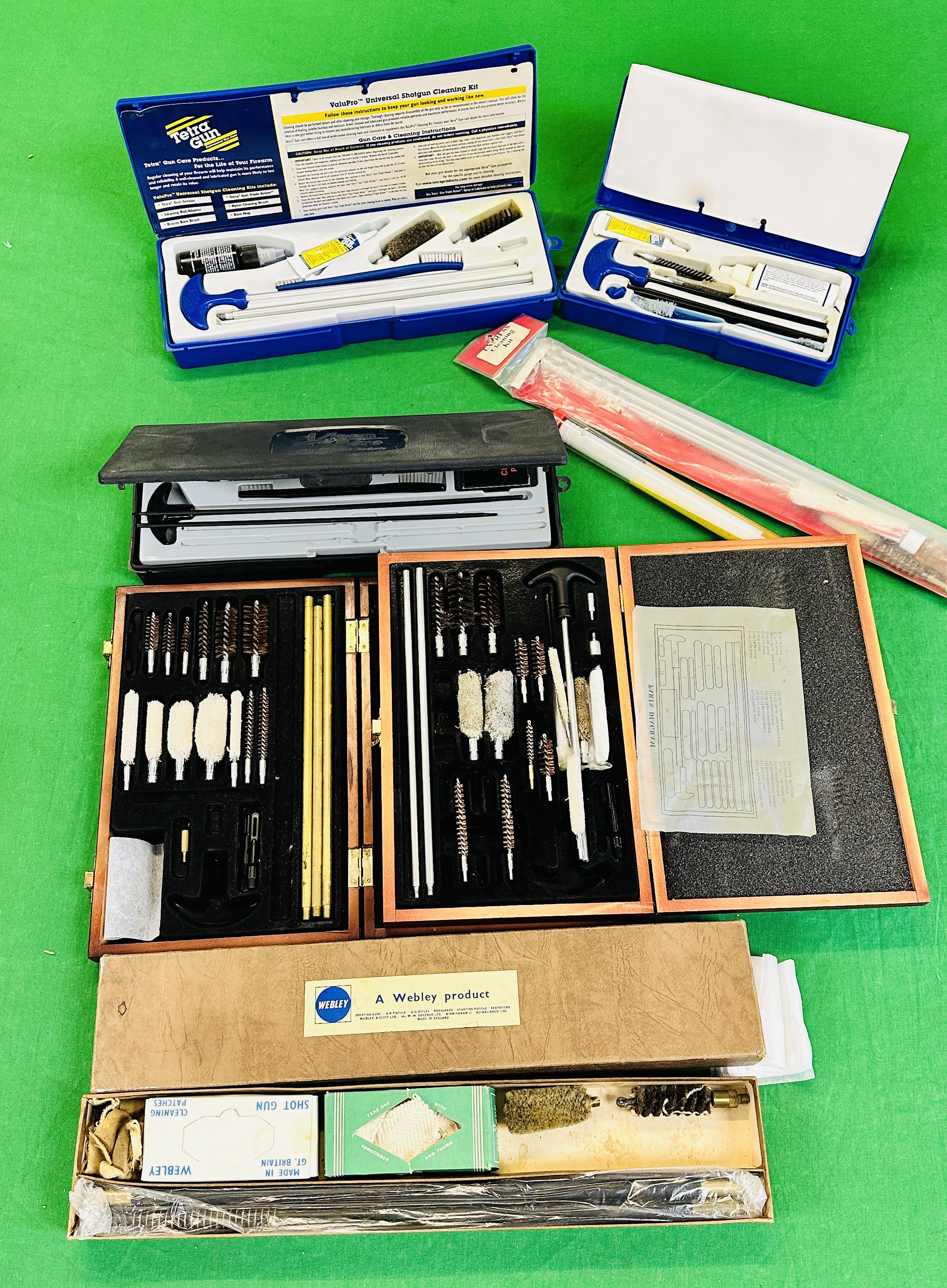 A BOX CONTAINING VARIOUS GUN CLEANING KITS AND EQUIPMENT TO INCLUDE TETRA.