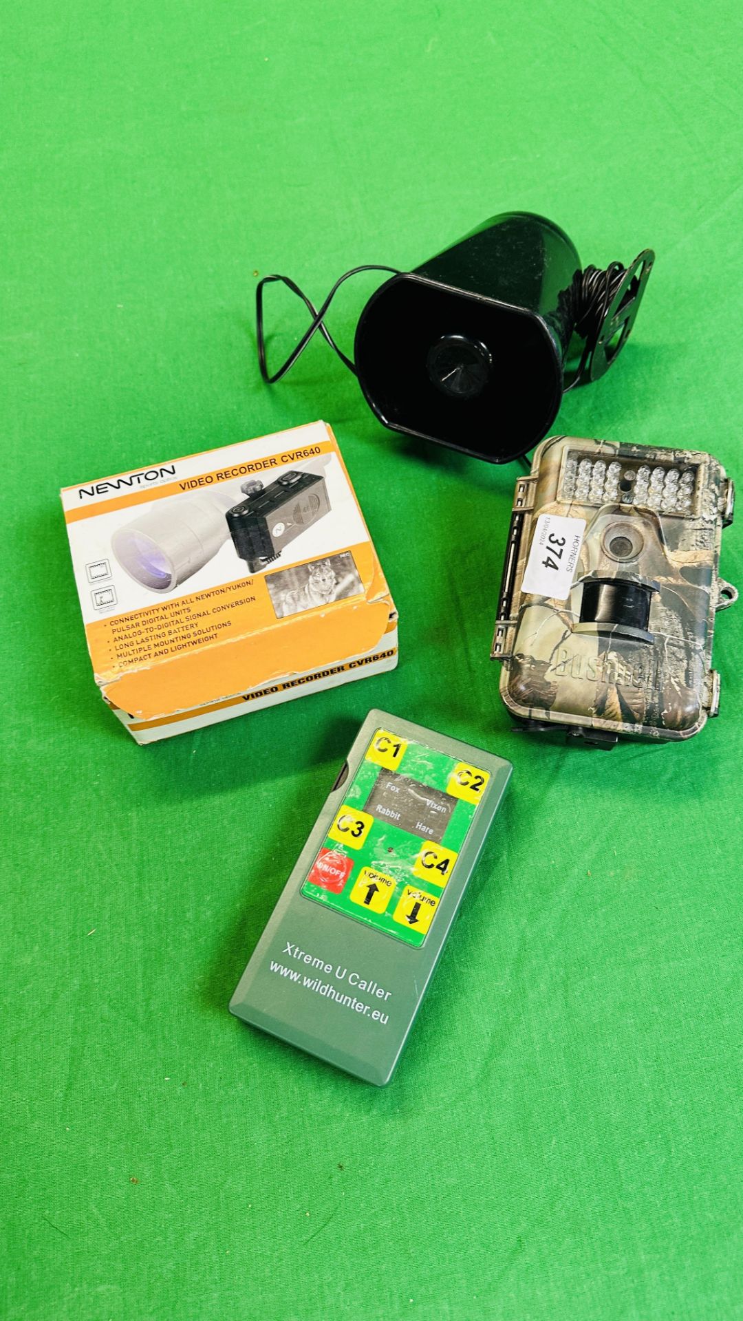 A BUSHNELL CAMOUFLAGE MOTION SENSOR WILDLIFE CAMERA ALONG WITH AN EXTREME U CALLER,