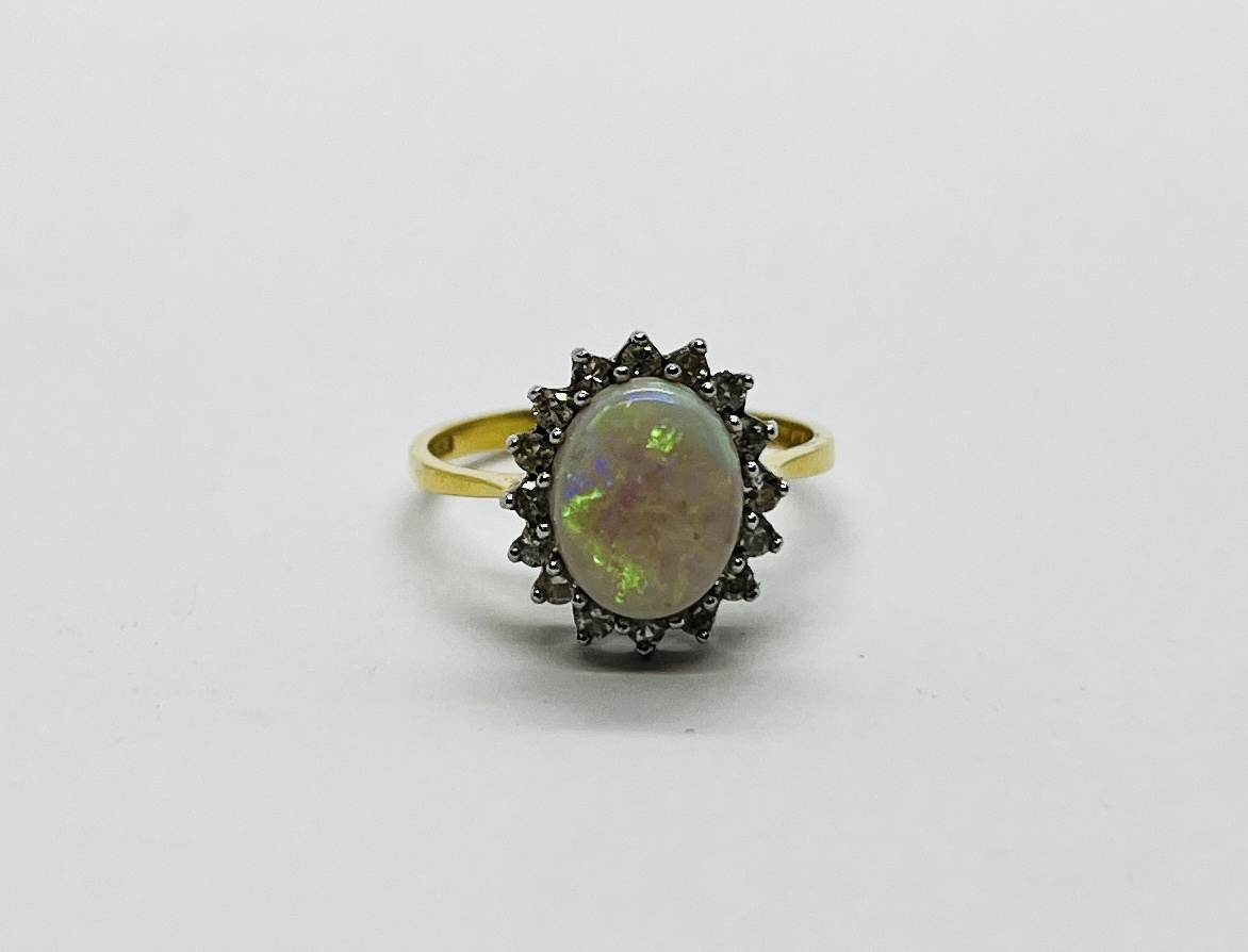 AN 18CT GOLD RING SET WITH A CENTRAL OVAL OPAL SURROUNDED BY DIAMONDS. - Image 2 of 12