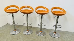 A SET OF FOUR RETRO STYLE BURNT ORANGE ADJUSTABLE BREAKFAST BAR STOOLS ON A CHROME BASE.