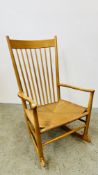 A DANISH MOBLER BEECHWOOD FRAMED HIGH BACK ROCKING CHAIR WITH RUSH SEAT.