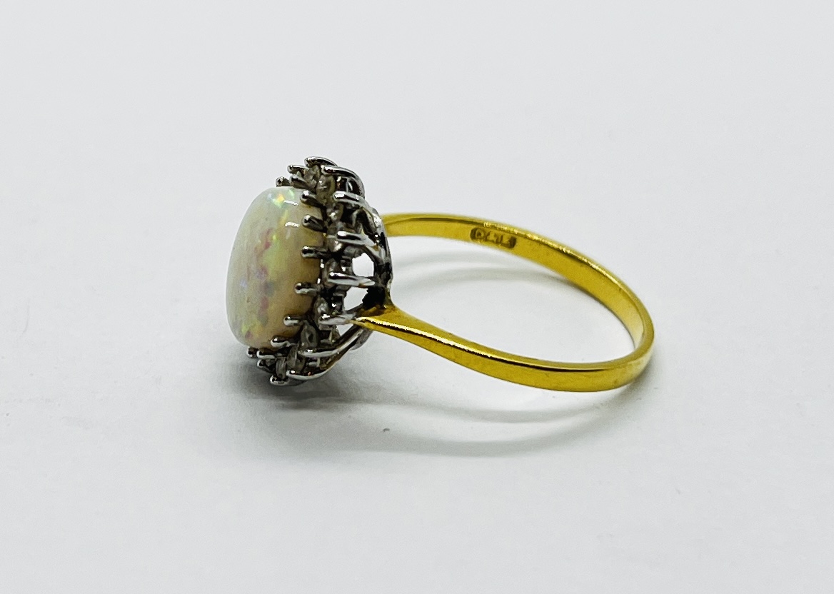 AN 18CT GOLD RING SET WITH A CENTRAL OVAL OPAL SURROUNDED BY DIAMONDS. - Image 6 of 12