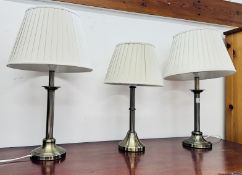 A PAIR OF DESIGNER ANTIQUE BRASS EFFECT TABLE LAMPS AND 1 FURTHER SIMILAR - ALL WITH PLEATED CREAM