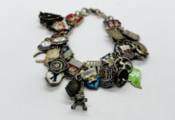 A WHITE METAL AND ENAMELED BRACELET HAVING APPROXIMATELY 23 SILVER CHARMS.