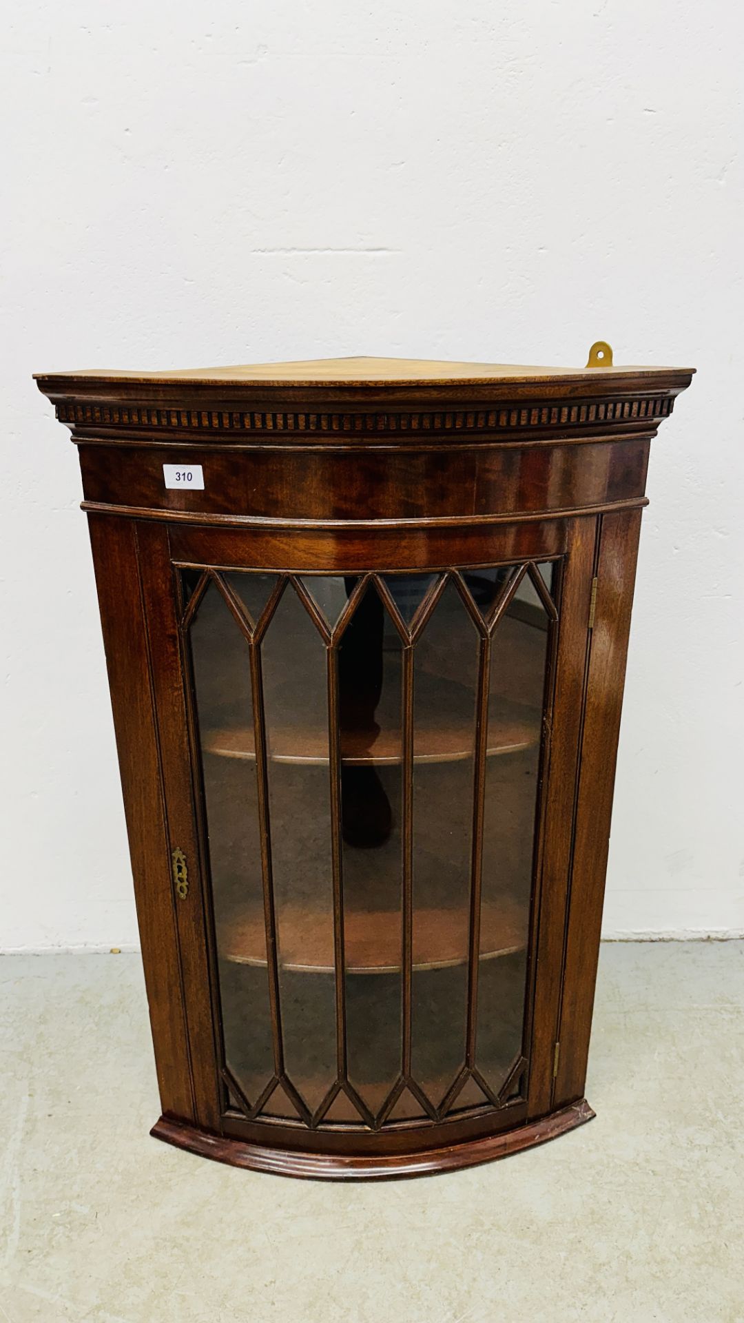 A REPRODUCTION BOW FRONT CORNER CABINET.