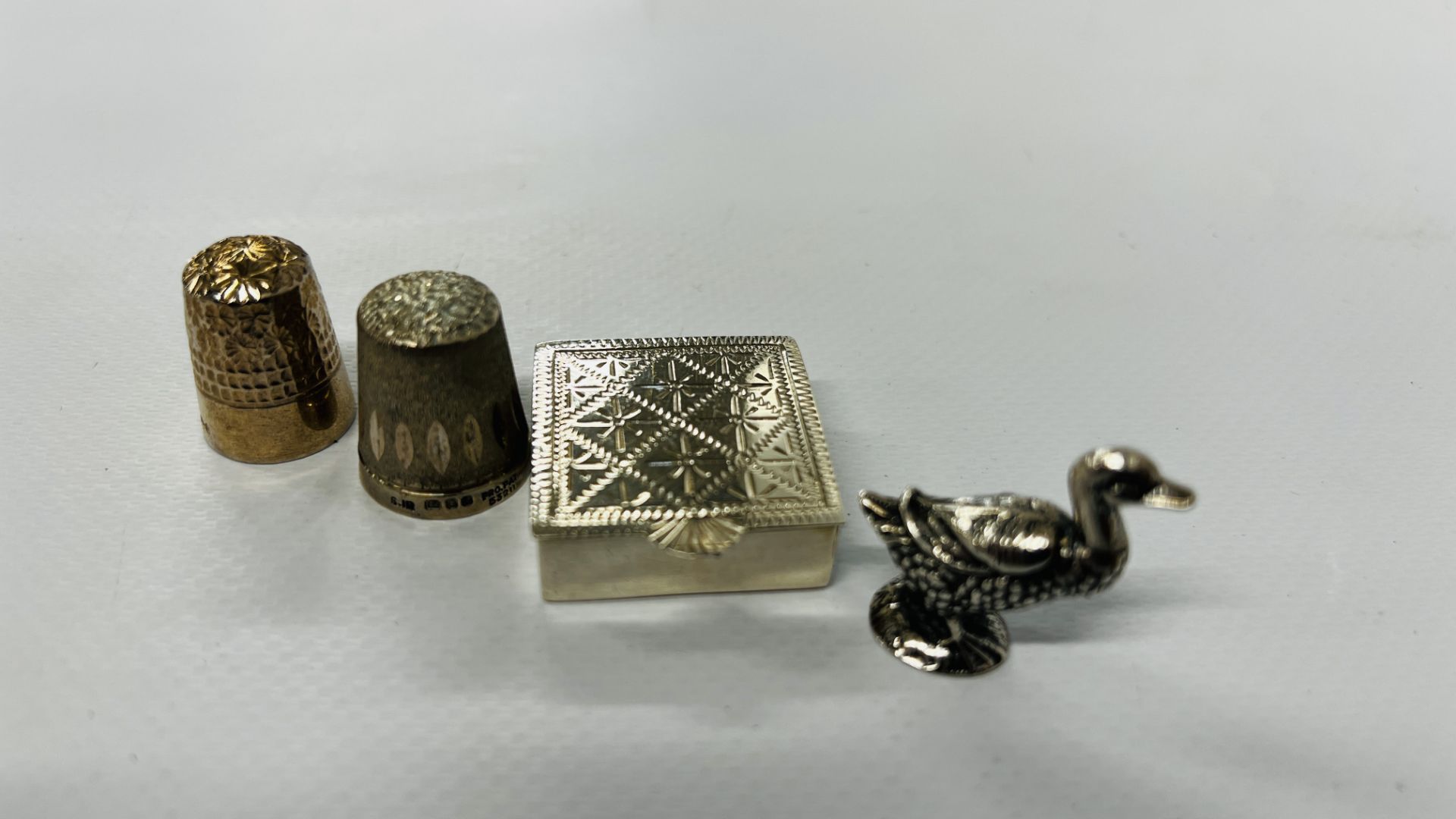 A SOLID SILVER DUCK, SILVER ENGRAVED PILL BOX AND 2 SILVER THIMBLES. - Image 3 of 8