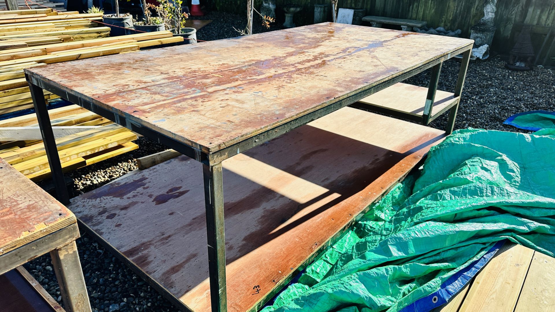 A HEAVY DUTY STEEL FRAMED WORK BENCH 122 X 244CM. THIS LOT IS SUBJECT TO VAT ON HAMMER PRICE.