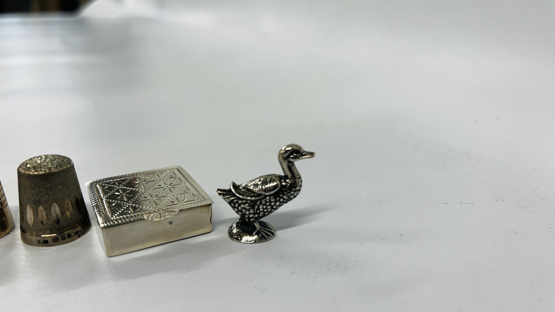 A SOLID SILVER DUCK, SILVER ENGRAVED PILL BOX AND 2 SILVER THIMBLES. - Image 2 of 8