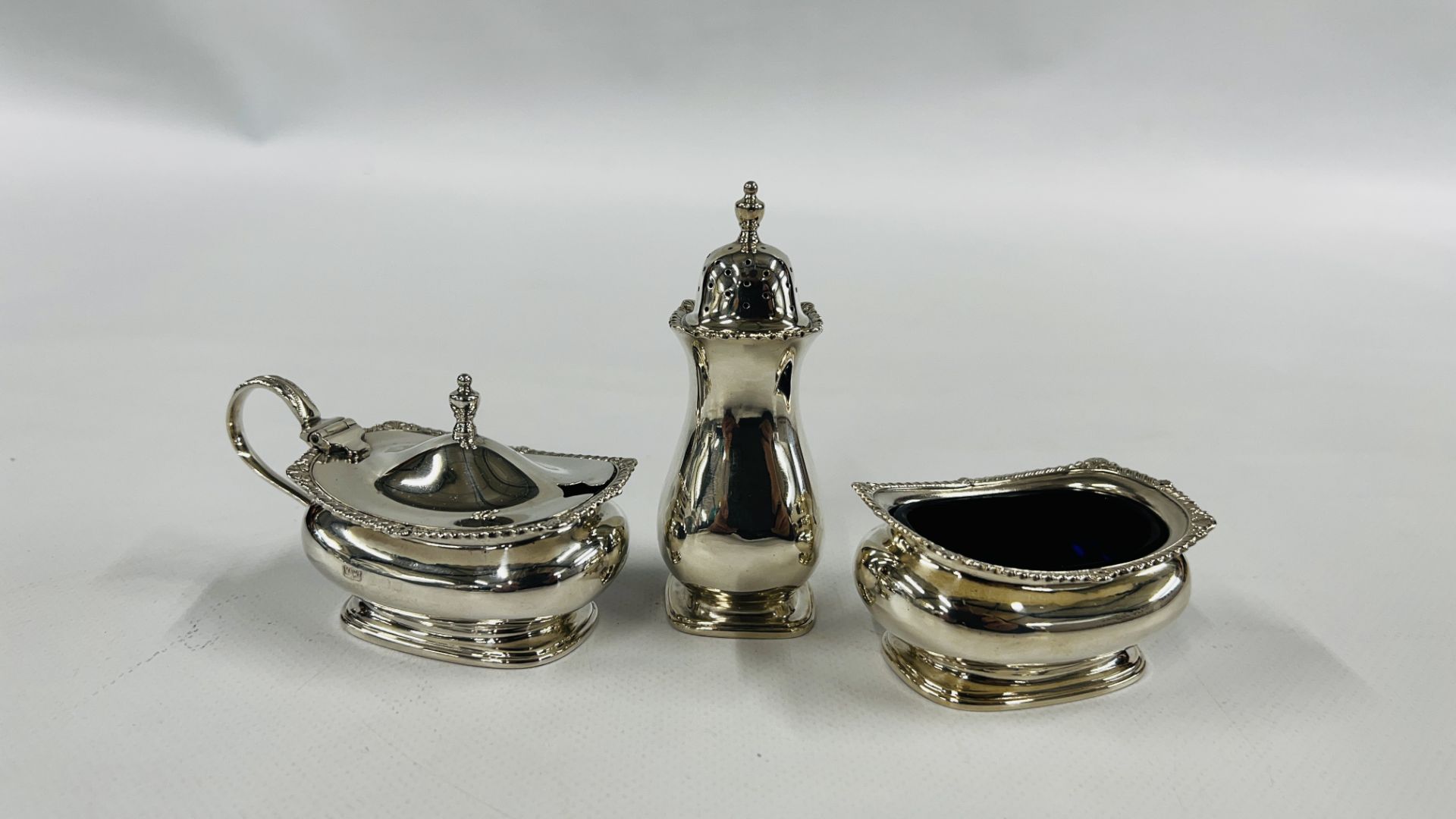 A SILVER THREE PIECE CONDIMENT SET, BIRMINGHAM ASSAY (RUBBED MARKS).