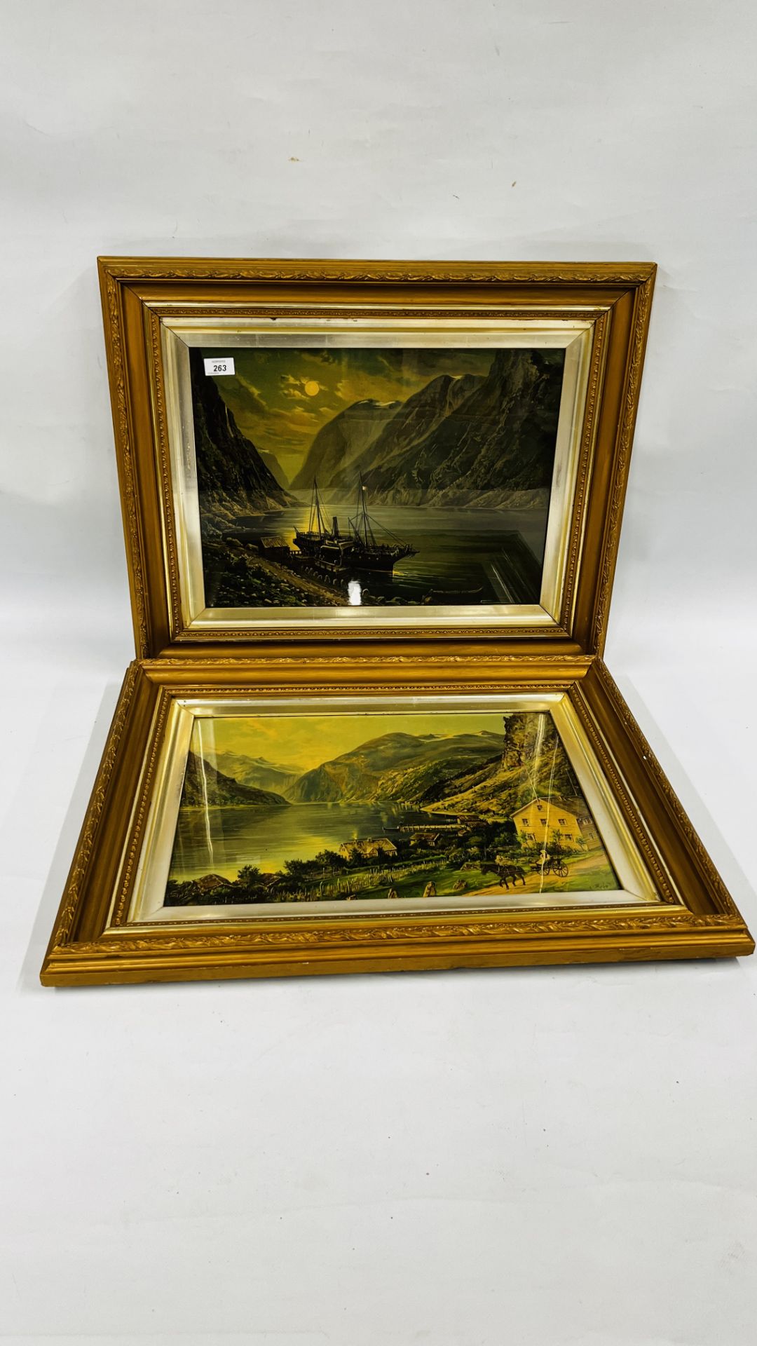 A PAIR OF ORNATE GILT FRAMED PRINTS DEPICTING CONTINENTAL SEA SCAPES.