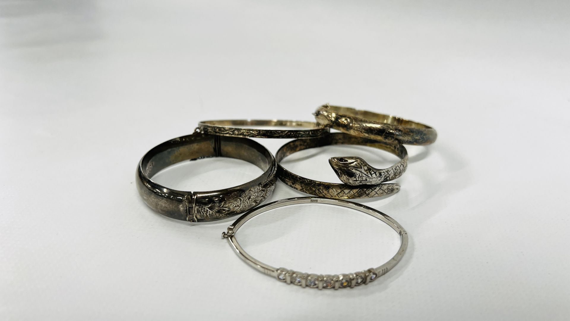 A GROUP OF 5 SILVER BANGLES TO INCLUDE A SNAKE, STONE SET EXPANDING AND ENGRAVED.