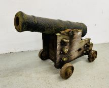 A GEORGE III CAST IRON NAVAL CANNON LENGTH 86CM ON LATER HARDWOOD STAND WITH CAST IRON WHEELS -