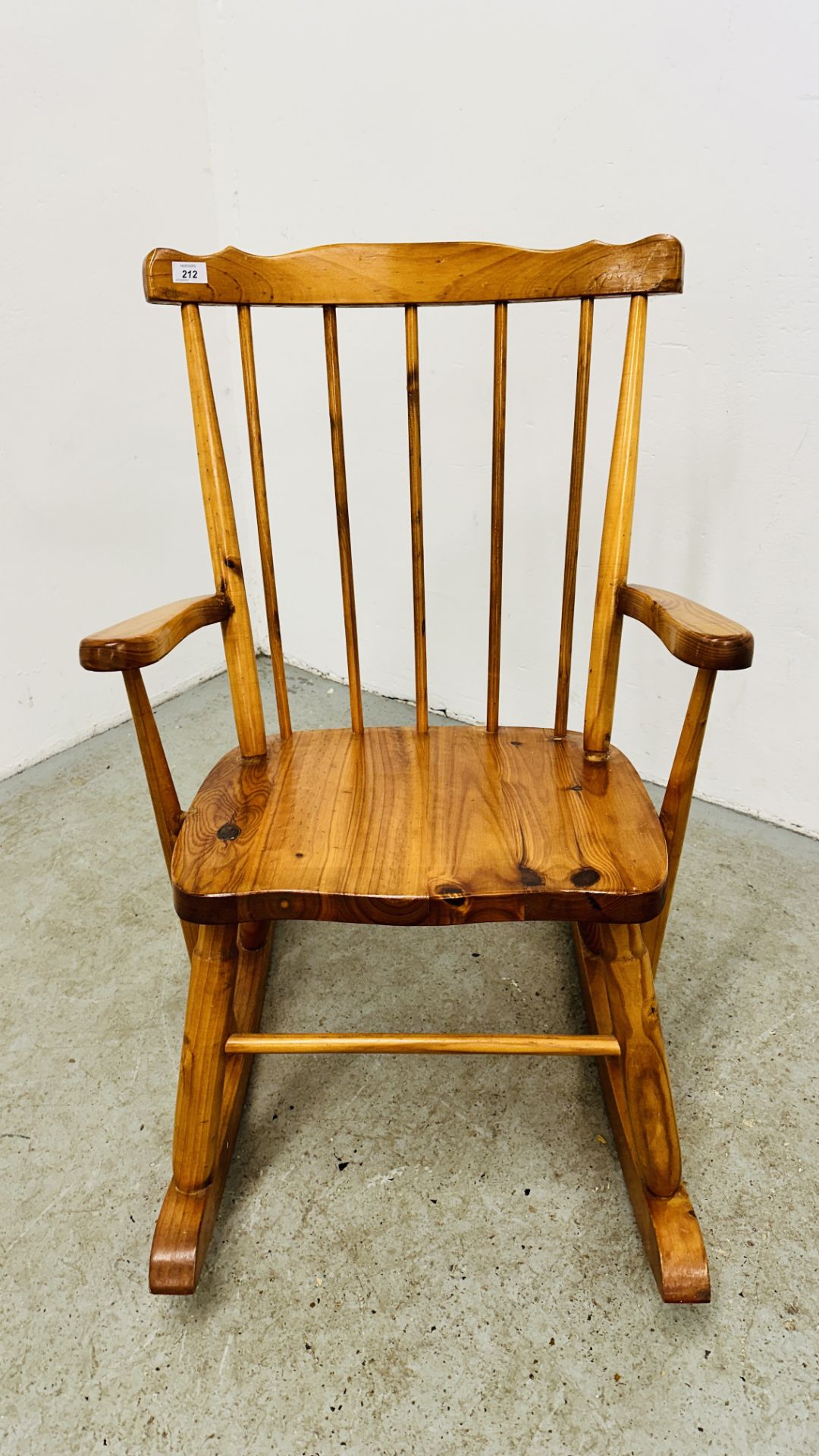 A PINE STICK BACK ROCKING CHAIR.