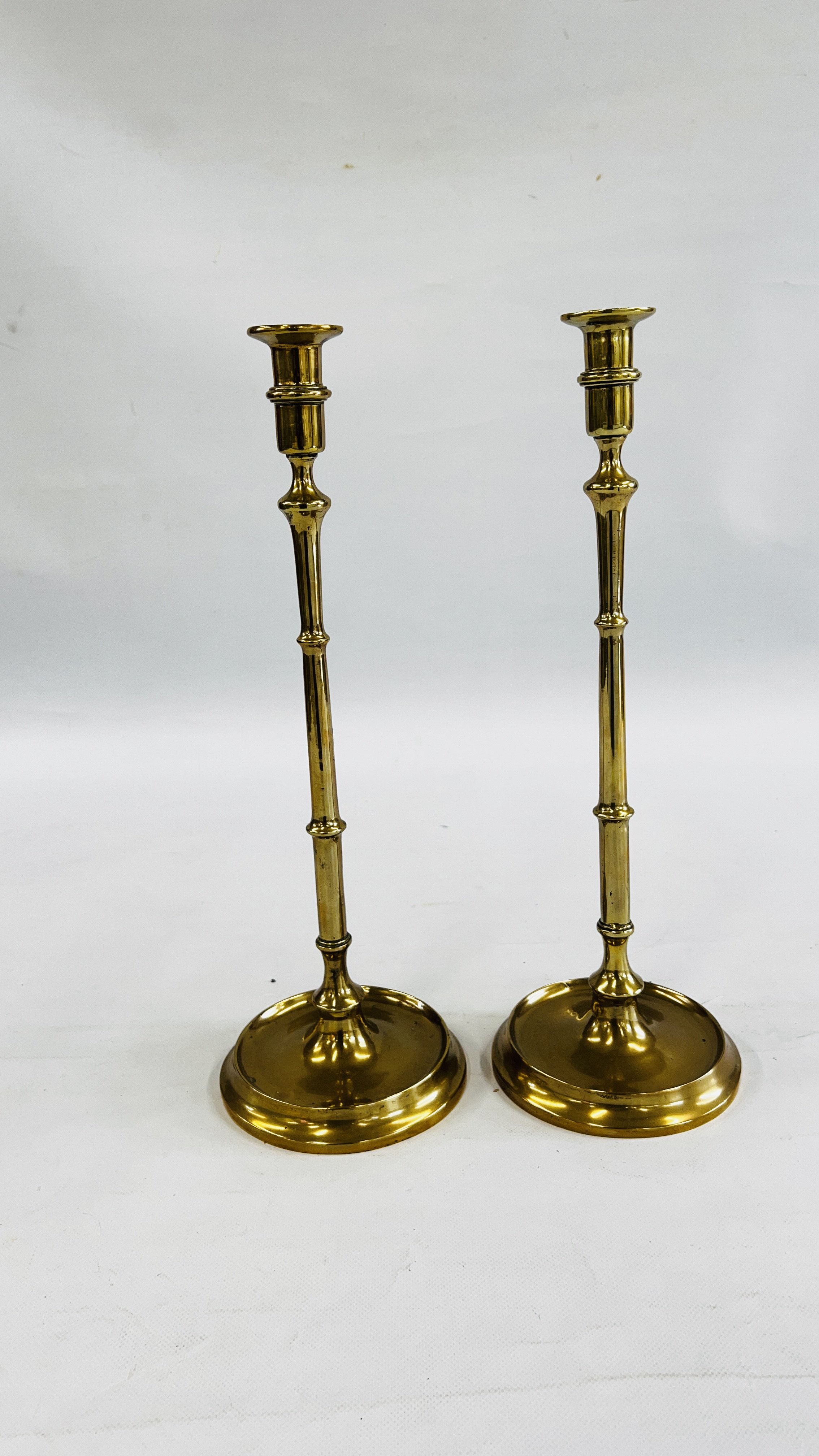 A PAIR OF HEAVY TALL BRASS CANDLESTICKS - HEIGHT 46CM.