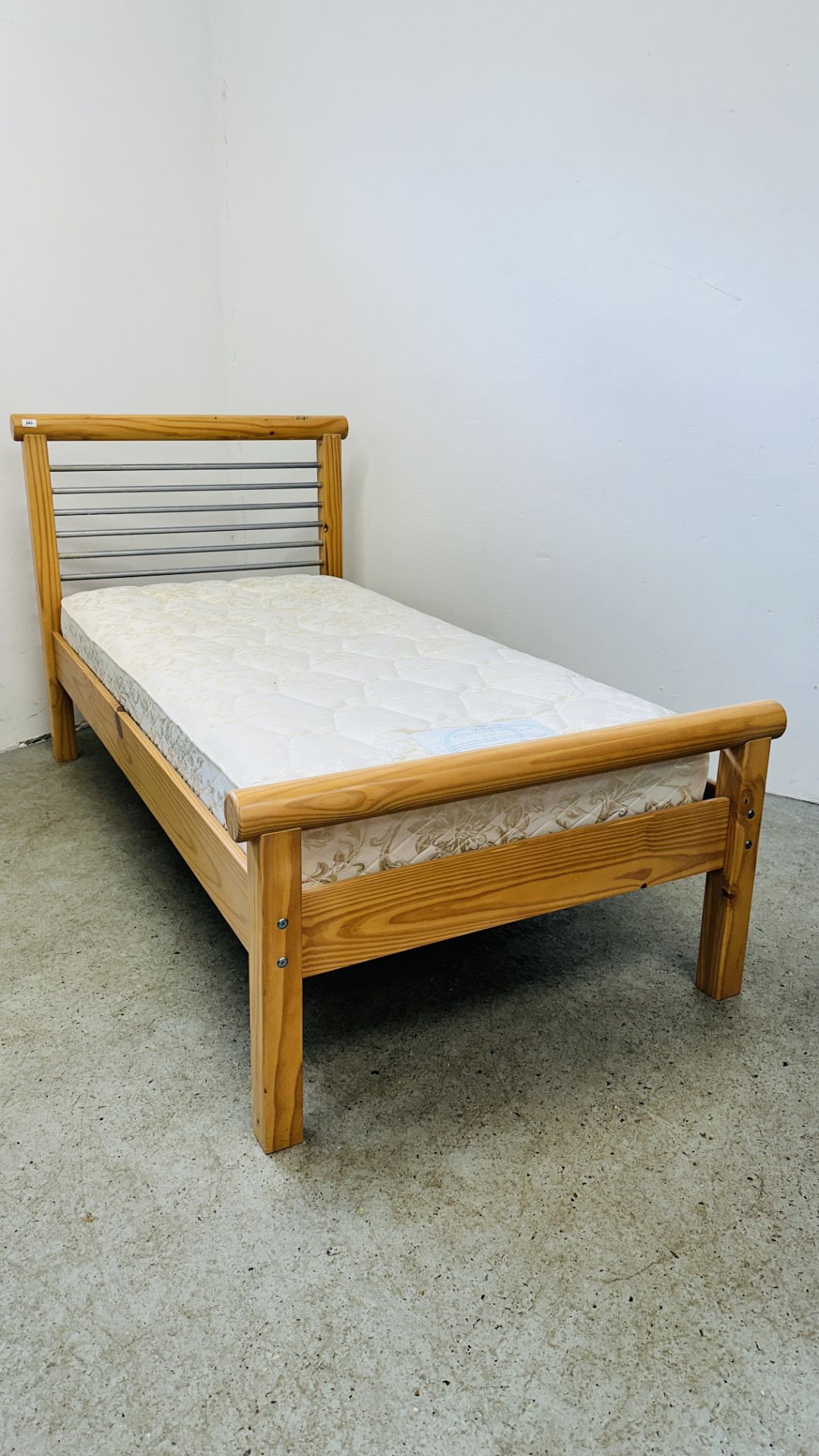 A MODERN PINE FRAMED SINGLE BED WITH STAINLESS STEEL BAR HEADBOARD COMPLETE WITH DORLUX FLEXIFORM