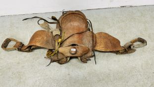 A VINTAGE WESTERN COWBOY SADDLE, THE TAN LEATHER WITH EMBOSSED DECORATION.