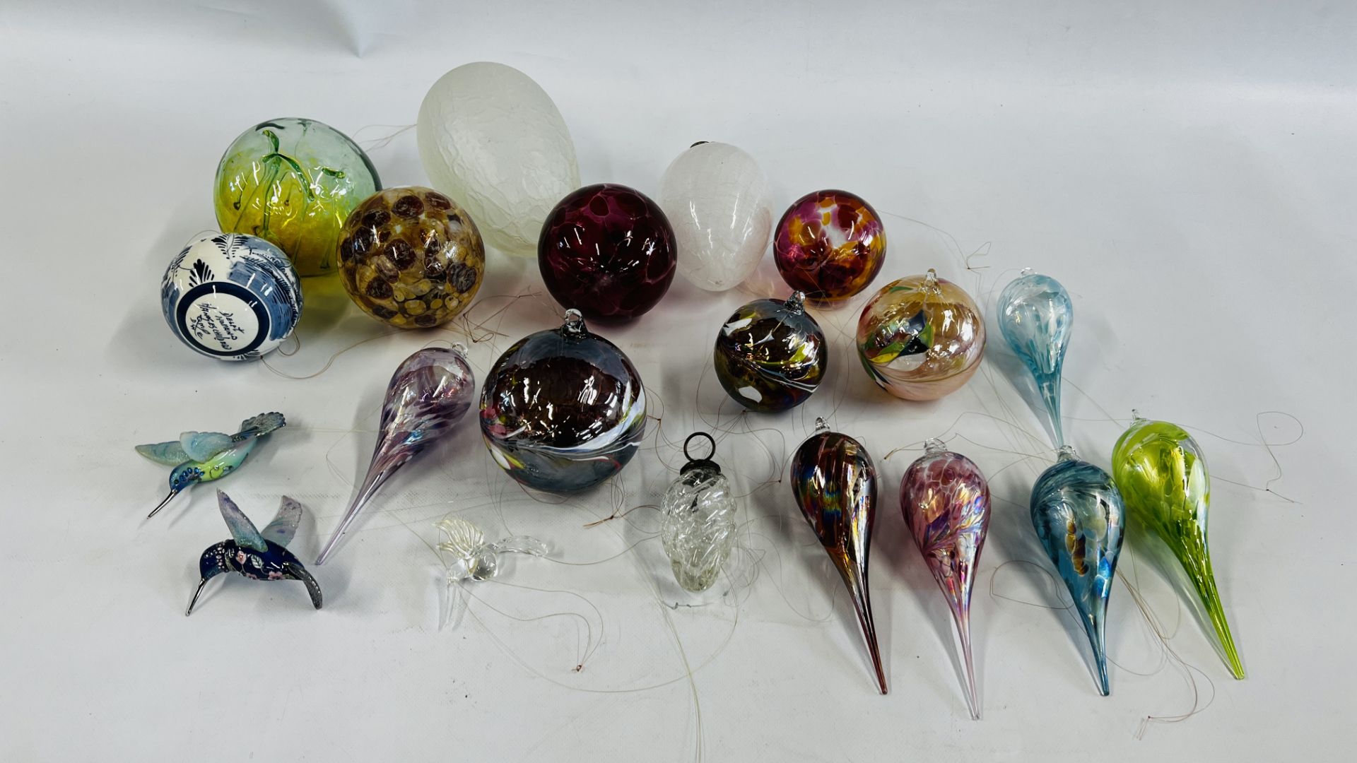 A GROUP OF ART GLASS HANGING BALLS AND ART GLASS HUMMING BIRDS.