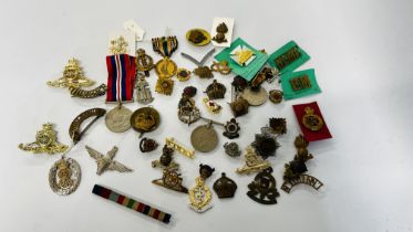 A COLLECTION OF ASSORTED MEDALS AND BADGES TO INCLUDE MANY MILITARY RELATED EXAMPLES.