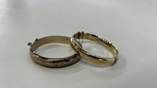 TWO SILVER ENGRAVED HINGED BANGLES BOTH HAVING SAFETY CHAINS.
