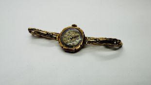 AN ANTIQUE 9CT GOLD CASED LADIES WRIST WATCH WITH AN ELABORATE GILDED ENAMEL DIAL ON A EXPANDABLE