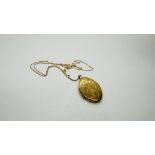 AN OVAL 9CT GOLD PHOTO LOCKET ON A FINE 9CT GOLD CHAIN - L 50CM.