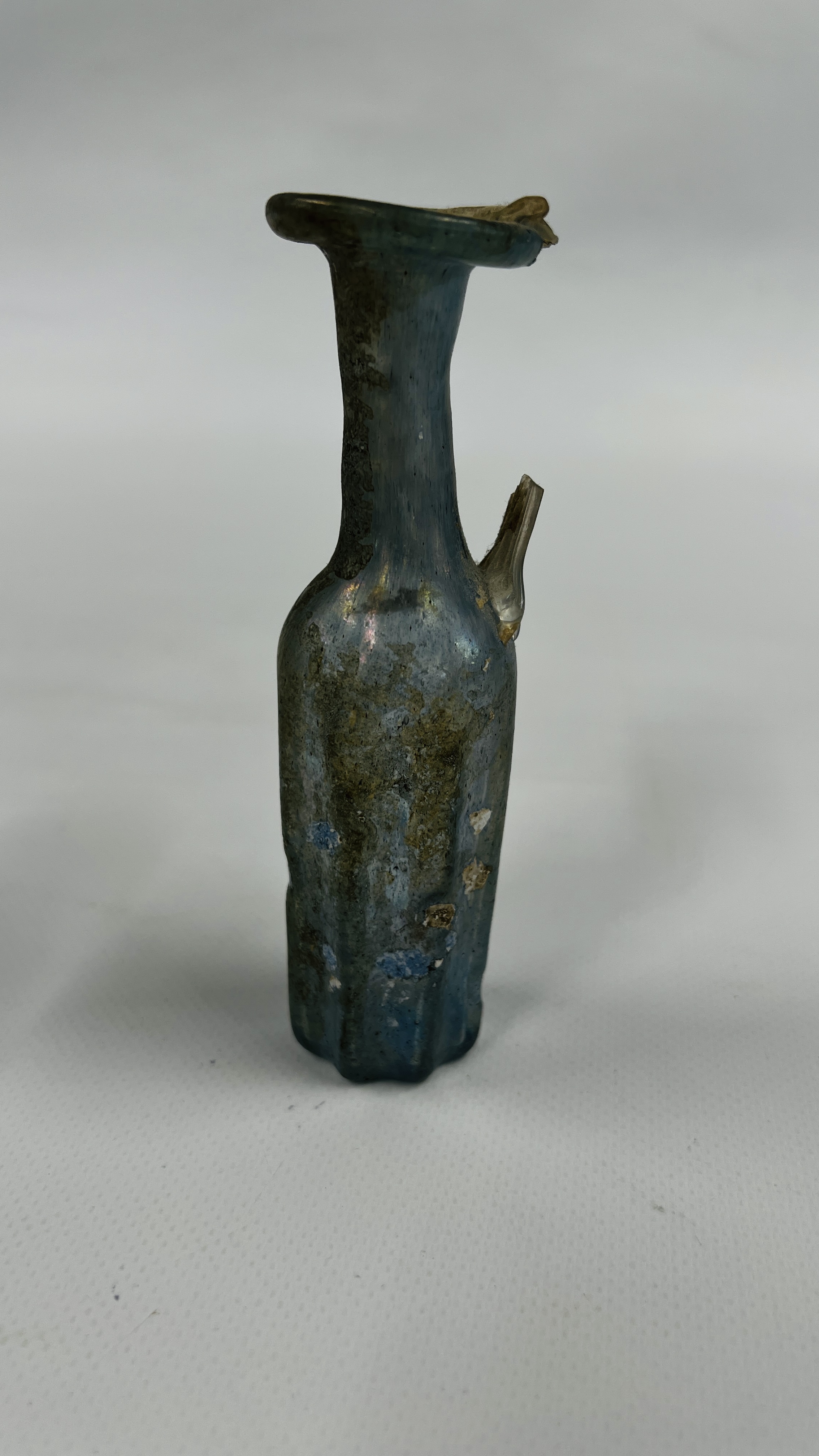 A VINTAGE ROMAN STYLE BOTTLE MOULDED FROM PALE BLUE TRANSLUCENT GLASS A/F H 13CM.