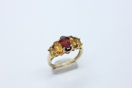 A MODERN 9CT GOLD RING SET WITH 5 GRADUATED CITRINE STONES.