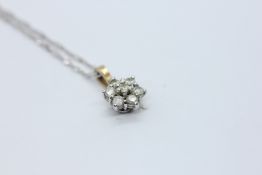 A 7 STONE DIAMOND FLOWER HEAD PENDANT ON A FINE WOVEN 9CT WHITE GOLD CHAIN L 47CM.