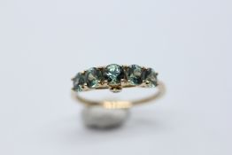 A MODERN DESIGNER 9CT GOLD RING SET WITH 5 PALE BLUE STONES AND TWO DIAMONDS WITHIN THE RAISED