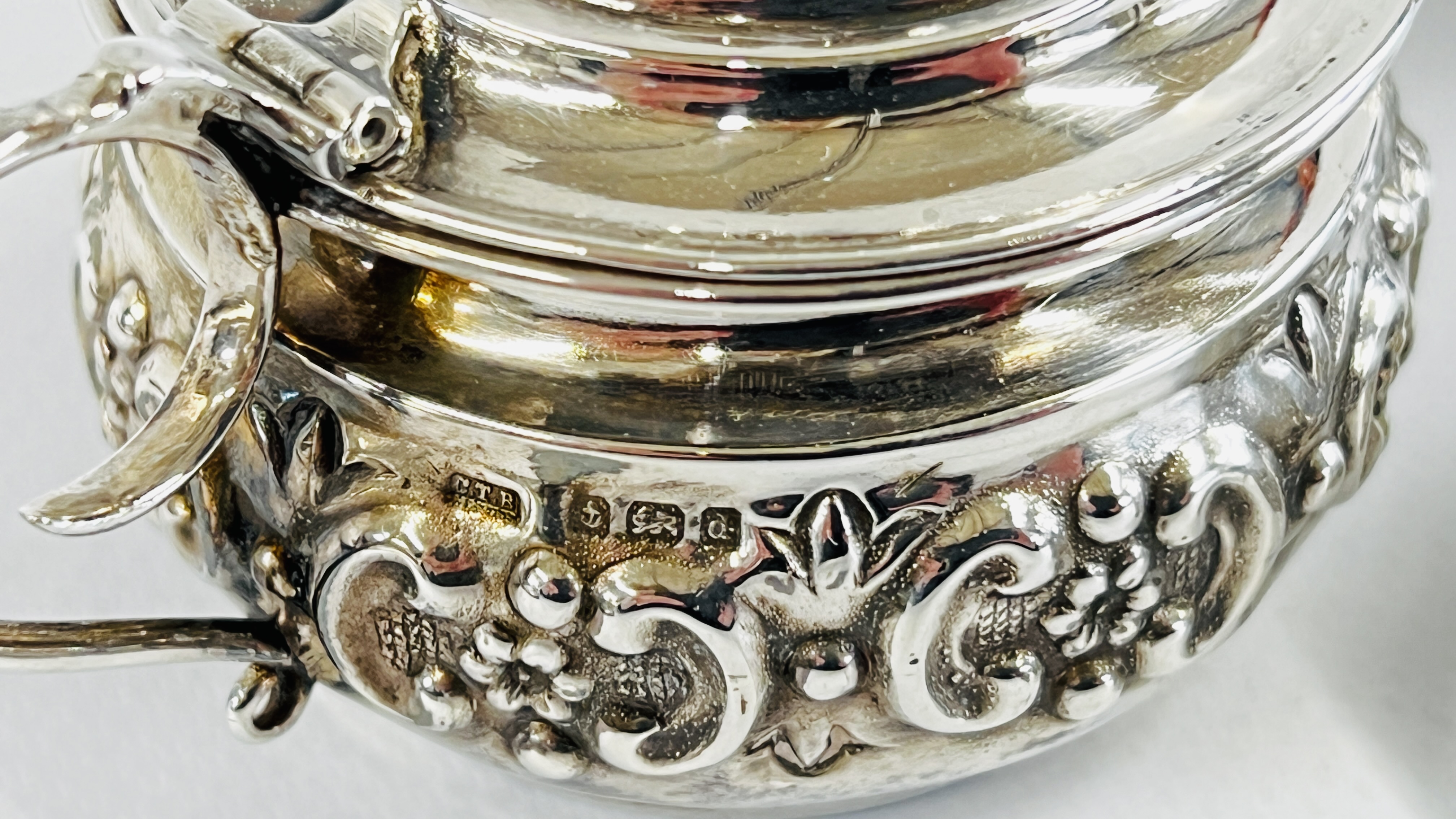 AN ELABORATE SILVER EMBOSSED MUSTARD POT AND BLUE GLASS LINER BIRMINGHAM ASSAY C.T.B. - Image 2 of 4