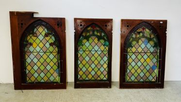 A SET OF 3 VINTAGE STAINED GLASS PANELS IN PINE MOUNTS.