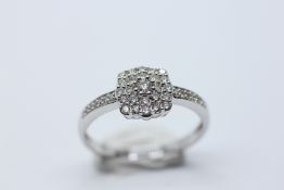 A MODERN 9CT WHITE GOLD DIAMOND CLUSTER RING.