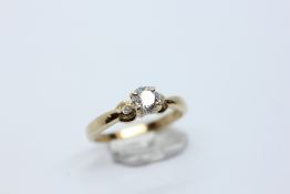 A RING SET WITH A ROUND BRILLIANT CUT NATURAL DIAMOND AND TWO SMALLER DIAMONDS EITHER SIDE MARKED