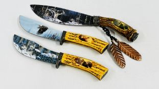 A GROUP OF THREE DECORATIVE KNIVES WITH HORN STYLE HANDLES THE BLADES DEPICTING WAVES AND EAGLES -