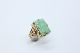 AN ELABORATE 9CT GOLD RING SET WITH AN ORIENTAL CARVED JADE PANEL H 1.8 X W 1.3CM.