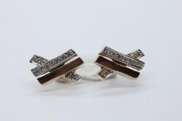 A PAIR OF 9CT GOLD STUD EARRINGS SET WITH DIAMONDS IN A CHANNEL SETTING.