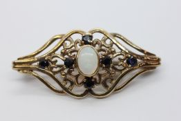 AN ELABORATE 9CT GOLD BROOCH SET WITH A CENTRAL OVAL OPAL. L 4CM.