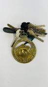 A VINTAGE BRASS AUTOMOBILE BADGE MARKED "ROYAL EAST AFRICA AUTOMOBILE ASSOCIATION" ALONG WITH A