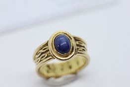 AN 18CT GOLD RING SET WITH A BLUE STAR SAPPHIRE ALONG WITH A GJA APPRAISAL SUMMARY CARD.