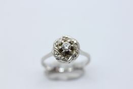 AN 18CT WHITE GOLD DIAMOND SOLITAIRE IN A DIAMOND KNOT SETTING.