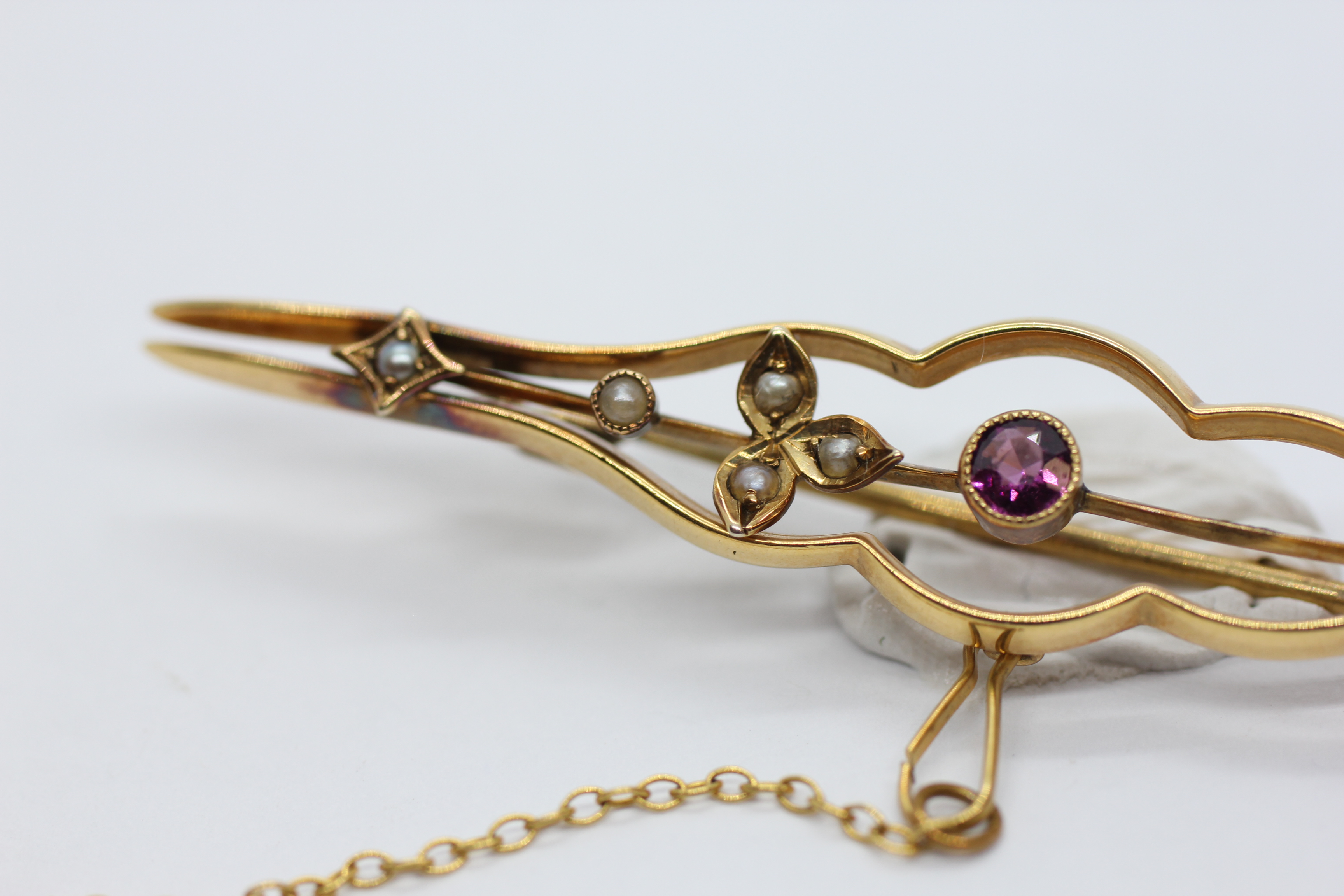 A VINTAGE 9CT GOLD BAR BROOCH AND SAFETY CHAIN SET WITH A CENTRAL AMETHYST AND SEED PEARLS - L 6. - Image 5 of 8