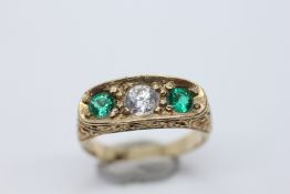 AN IMPRESSIVE 9CT GOLD 3 STONE RING SET WITH A CENTRAL CLEAR STONE AND A VIVID GREEN STONE TO