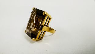 A VINTAGE YELLOW METAL COCKTAIL RING SET WITH A LARGE EMERALD CUT SMOKY QUARTZ.