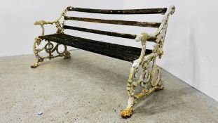 AN ORNATE CAST IRON GARDEN BENCH, THE BENCH ENDS DETAILED WITH SNAKES AND VINES,