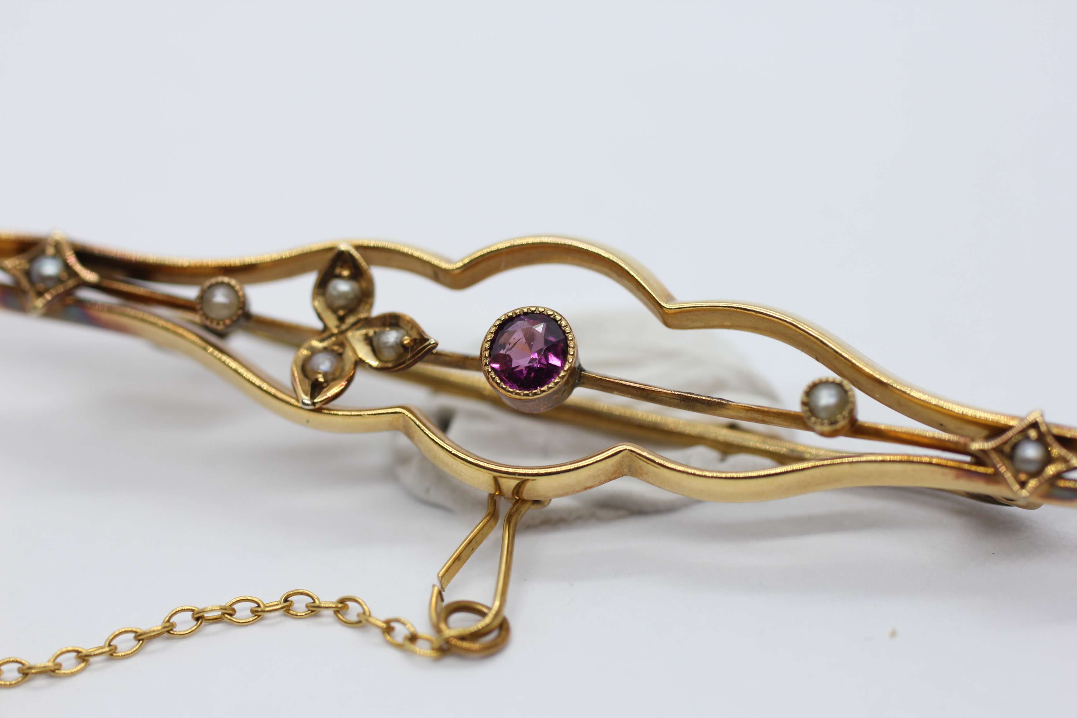 A VINTAGE 9CT GOLD BAR BROOCH AND SAFETY CHAIN SET WITH A CENTRAL AMETHYST AND SEED PEARLS - L 6. - Image 2 of 8