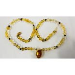 AN ELEGANT BEADED NECKLACE, THE CITRINE PENDANT ENCASED WITHIN AN 18CT GOLD SETTING. L 44CM.