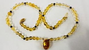 AN ELEGANT BEADED NECKLACE, THE CITRINE PENDANT ENCASED WITHIN AN 18CT GOLD SETTING. L 44CM.