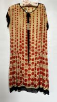 1920S MUSLIN BEIGE DROP WAISTED DRESS WITH RED SPOTS, BLACK TRIM TO SLEEVES,