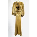 1930S GOLD LAMÉ EVENING DRESS WITH CAPE, RUCHED BODICE WITH FLOWERS AND BELT - A/F CONDITION,